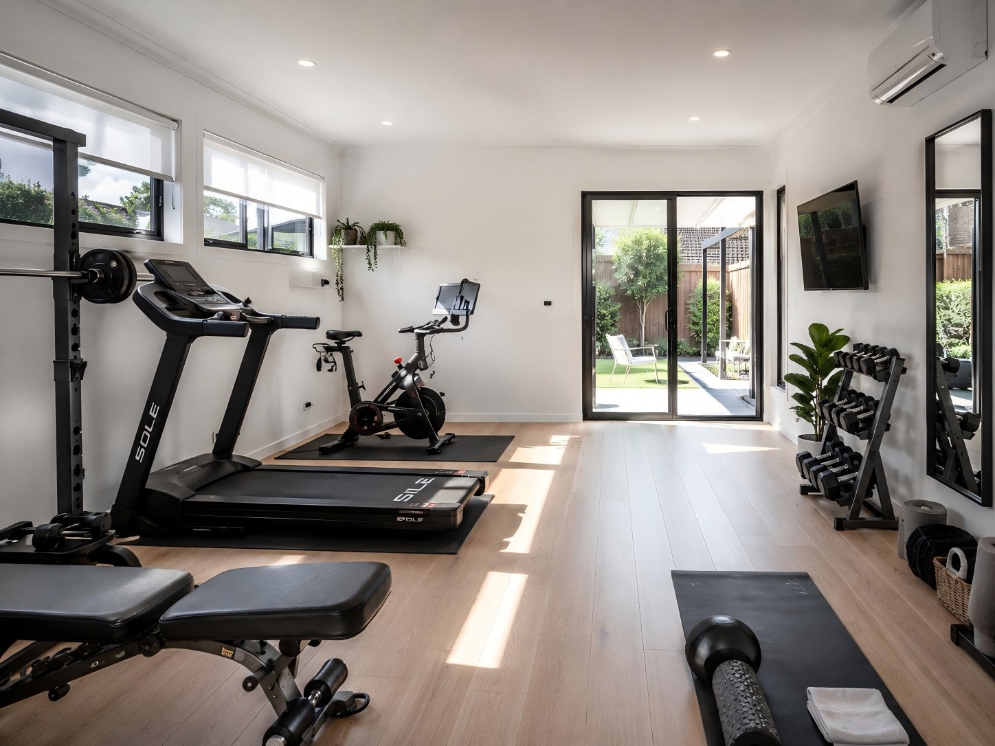 Private home gym with exercise equipment and a connection to the garden