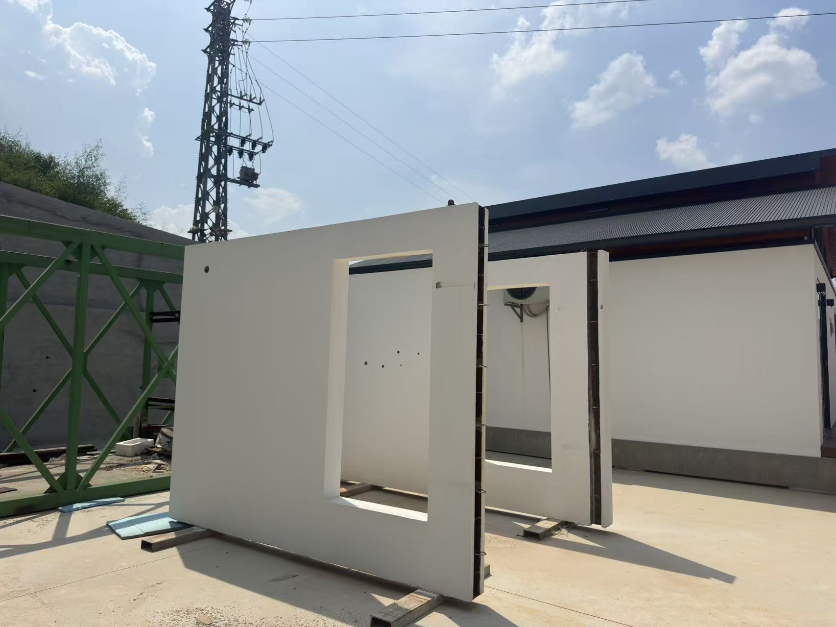 Precast wall panels with window and door openings standing in a working yard